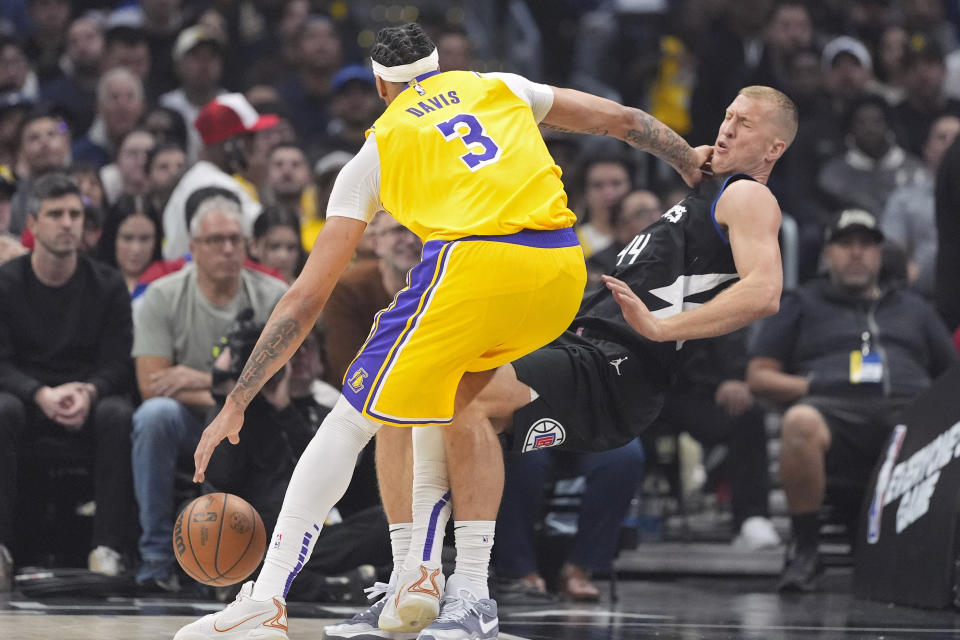 Los Angeles Lakers forward Anthony Davis, left, knocks over Los Angeles Clippers center Mason Plumlee as he drives to the basket during the first half of an NBA basketball game Wednesday, Feb. 28, 2024, in Los Angeles. (AP Photo/Mark J. Terrill)