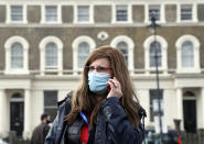 Dr Sharon Raymond make a call to one the London Taxi cabs being used during a pilot project of pop up vaccination drive called Vaxi Taxi in Kilburn, London, Sunday, Feb. 28, 2021. The pilot scheme, funded by the Covid Crisis Rescue Foundation, aims to help ferry supplies and patients to temporary clinics set up in faith and community centers across the capital. Dr Sharon Raymond, director of the foundation, said the scheme will provide people with an alternative to their GP surgery and will allow them to be in a "familiar place" when receiving a coronavirus vaccine. (AP Photo/Alastair Grant)