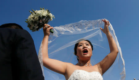 A bride reacts during a mass wedding ceremony for fifty Chinese couples in Colombo, Sri Lanka, December 17, 2017. REUTERS/Dinuka Liyanawatte
