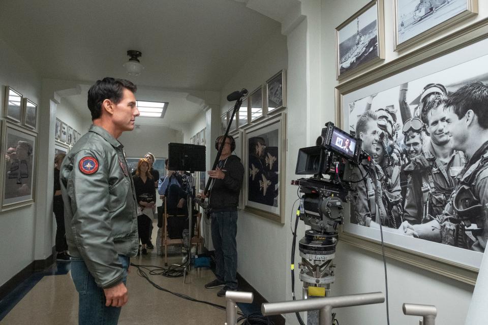 Tom Cruise looking at a photo of he and Val Kilmer