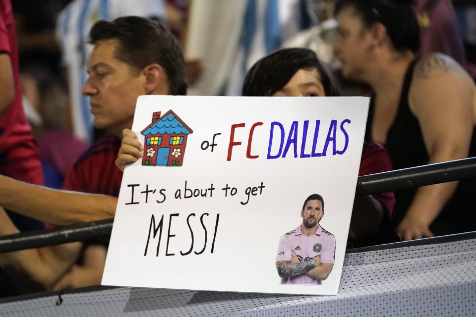 A fan holds a sign about Lionel Messi during the first half of a Leagues Cup soccer match between Inter Miami and FC Dallas on Sunday, Aug. 6, 2023, in Frisco, Texas. (AP Photo/LM Otero)