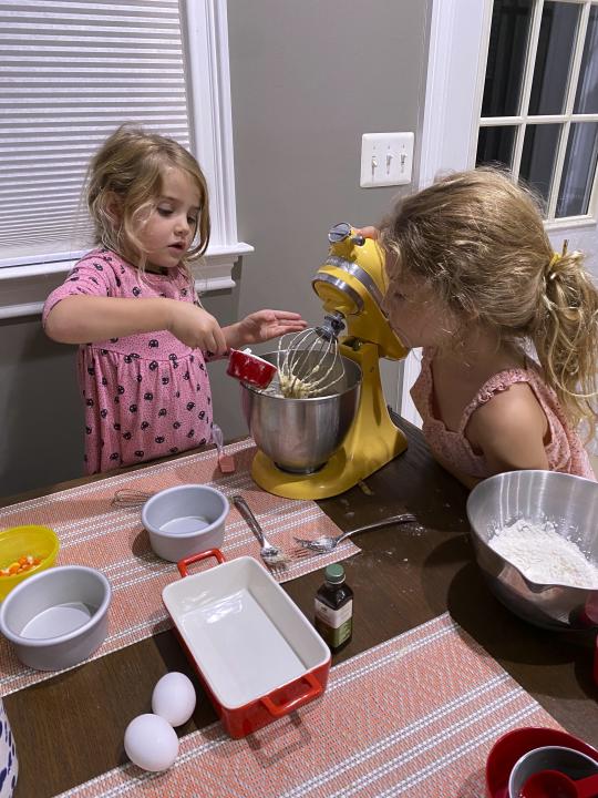 Danielle McWilliams' daughters Reese, 7, right, and Remi, 4, cook at their New Jersey home. Along with the usual cupcakes, crispy treats and from-scratch cookies, they make tarallis, an Italian family traditional treat that’s a cross between a breadstick, bagel and pretzel. (Danielle McWilliams via AP)