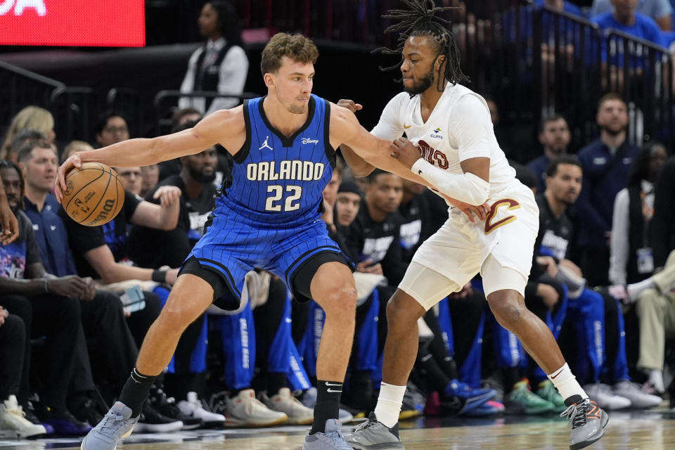 Orlando Magic forward Franz Wagner (22) makes a move on Cleveland Cavaliers guard Darius Garland, right, during the first half of Game 4 of a first-round NBA basketball playoff series, Saturday, April 27, 2024, in Orlando, Florida.  AP Photo/John Raoux)