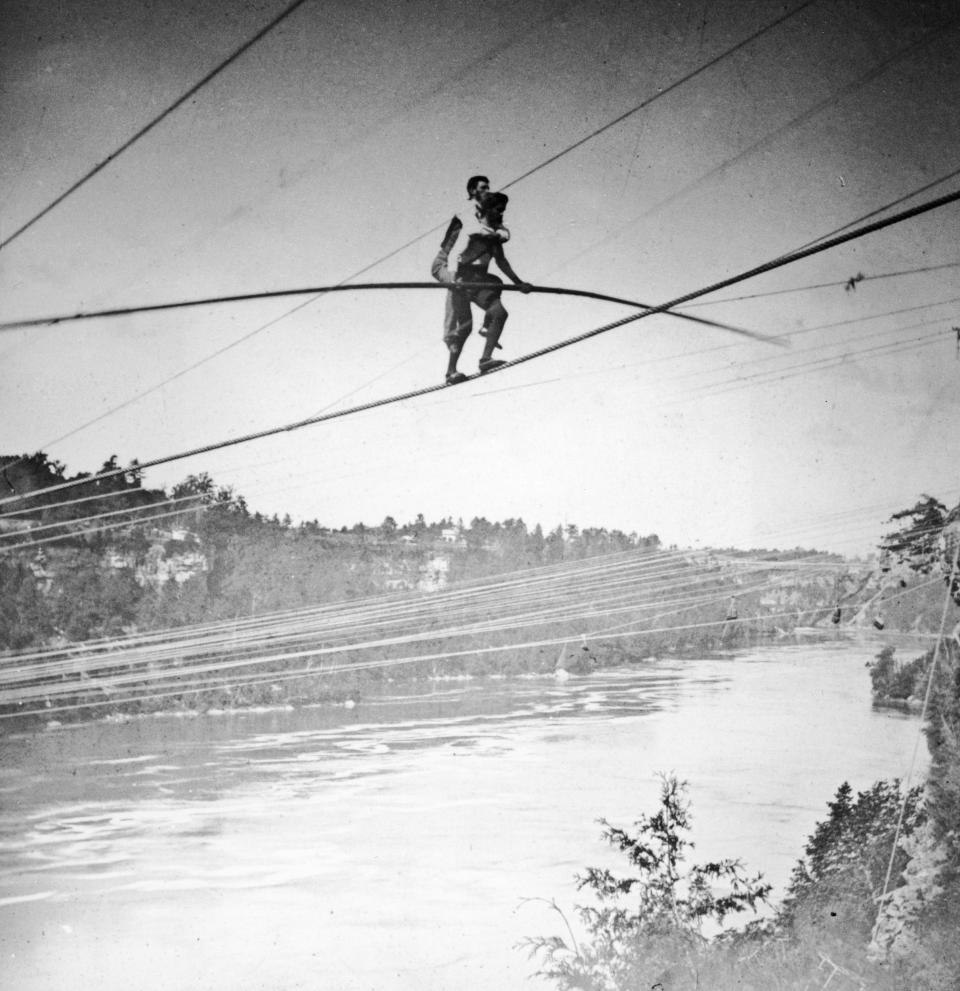 Jean Francois Gravelet tightrope walks across the Niagara River Gorge carrying his manager, Harry Colcord, on his back, in 1859.