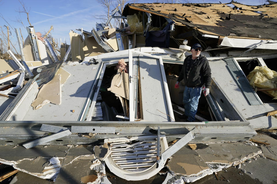 Kenny Sanford exits his mother-in-law's apartment through a collapsed wall Saturday, Dec. 11, 2021, in Mayfield, Ky. Tornadoes and severe weather caused catastrophic damage across several states Friday, killing multiple people overnight. (AP Photo/Mark Humphrey)