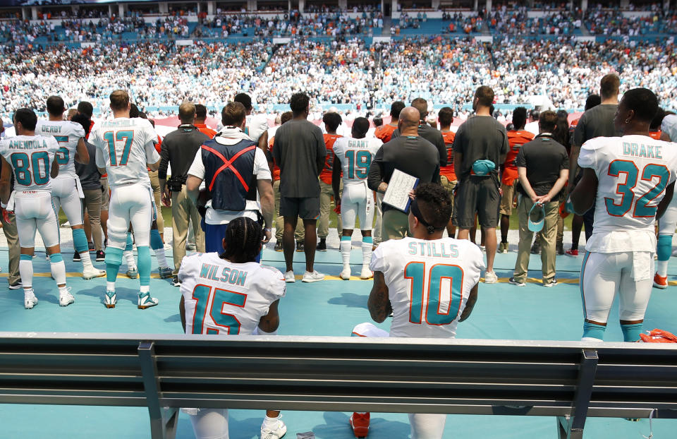 Miami Dolphins wide receiver Kenny Stills (10) and wide receiver Albert Wilson (15) take a knee during the singing of the national anthem before an NFL football game against the Oakland Raiders, Sunday, Sept. 23, 2018, in Miami Gardens, Fla. (AP Photo/Brynn Anderson)