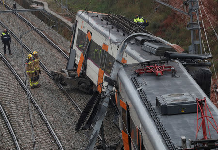 Rescue workers survey the scene after a commuter train derailed between Terrassa and Manresa, outside Barcelona, Spain, November 20, 2018. REUTERS/Albert Gea