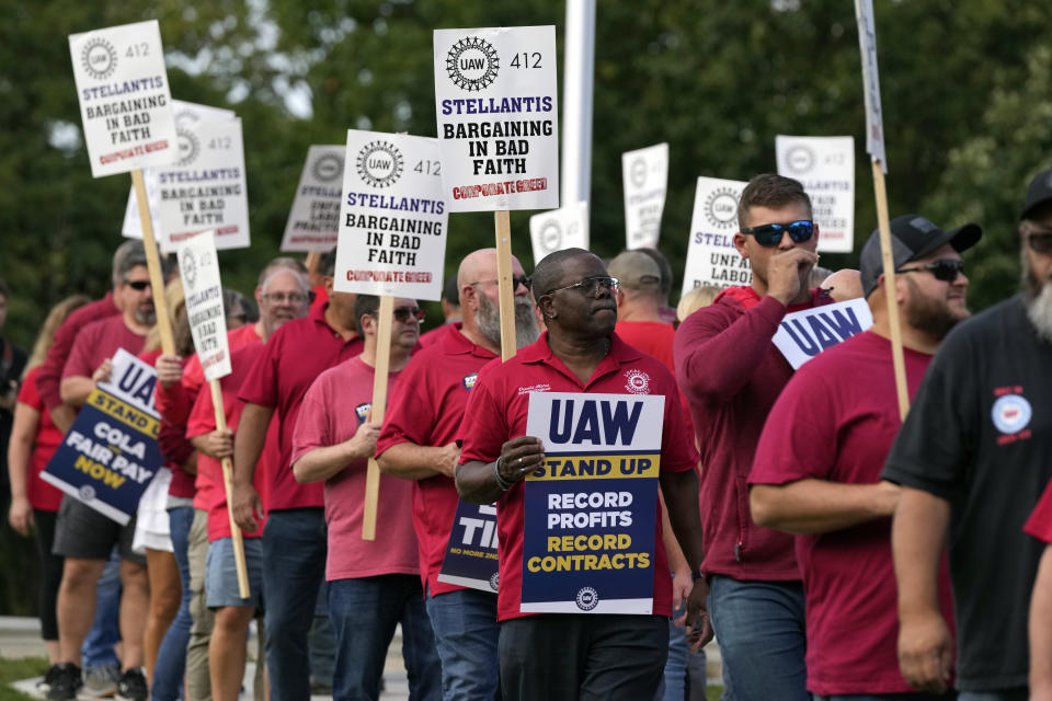 United Auto Workers march outside the Stellantis North American Headquarters, Wednesday, Sept. 20, 2023, in Auburn Hills, Mich. General Motors and Stellantis announced fresh layoffs Wednesday that they blamed on damage from the United Auto Workers strike, and the labor standoff grew more tense just two days before the union was expected to call for new walkouts. UAW President Shawn Fain said layoffs were unnecessary and an effort to pressure workers to settle for less in contract negotiations. (AP Photo/Carlos Osorio)