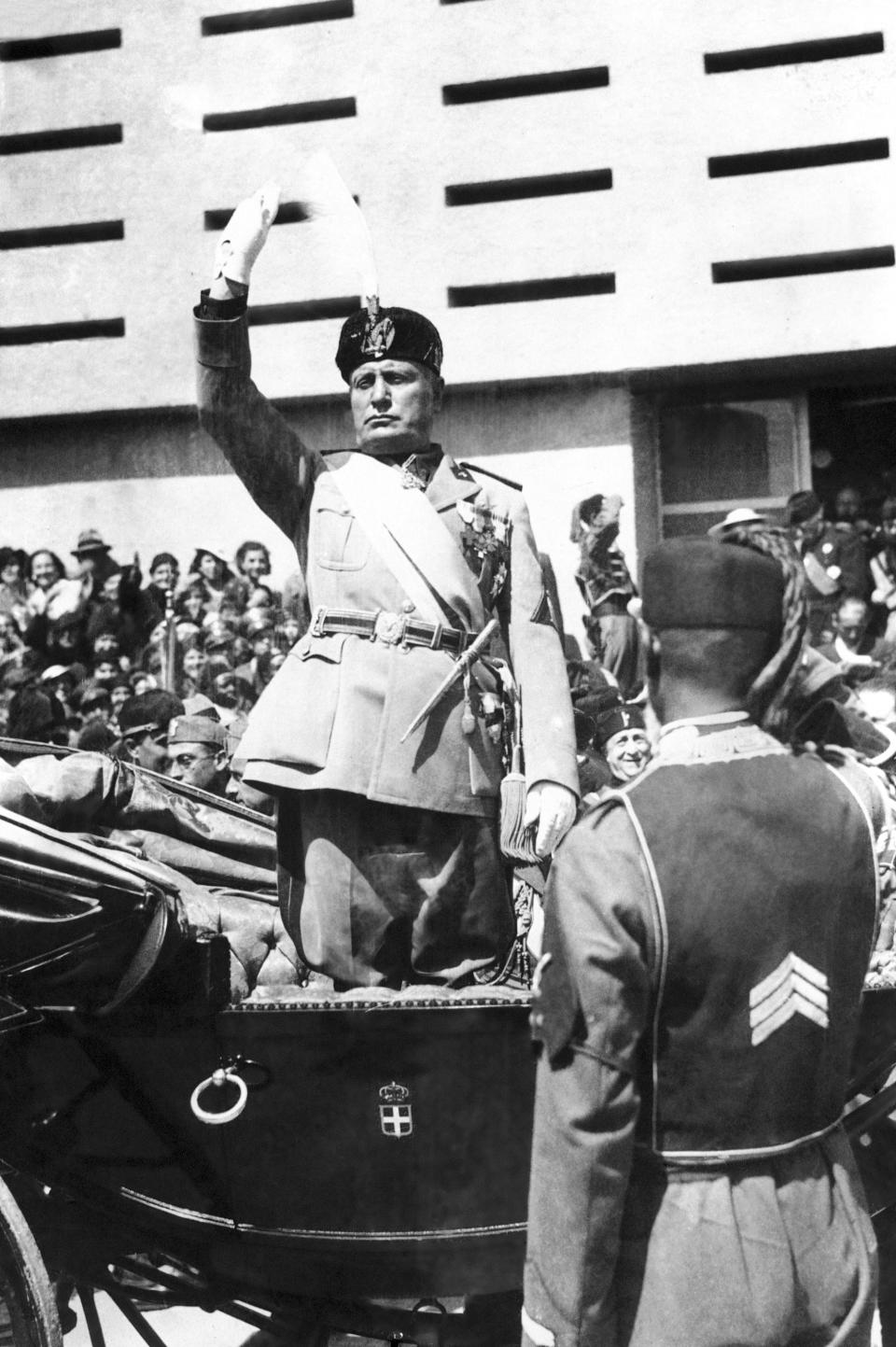 FILE - Italian dictator Benito Mussolini gives the Fascist salute before making his speech at the open ceremony of the Tripoli fair, in Tripoli, Libya, March 17, 1937. Italy, a long time victim of antiquities theft that has worked for decades to recover its treasures, is coming to terms with the fact that it, too has stolen loot in its museum collections: the relics of a brutal colonial empire that the country hasn't fully reckoned with. (AP Photo, File)