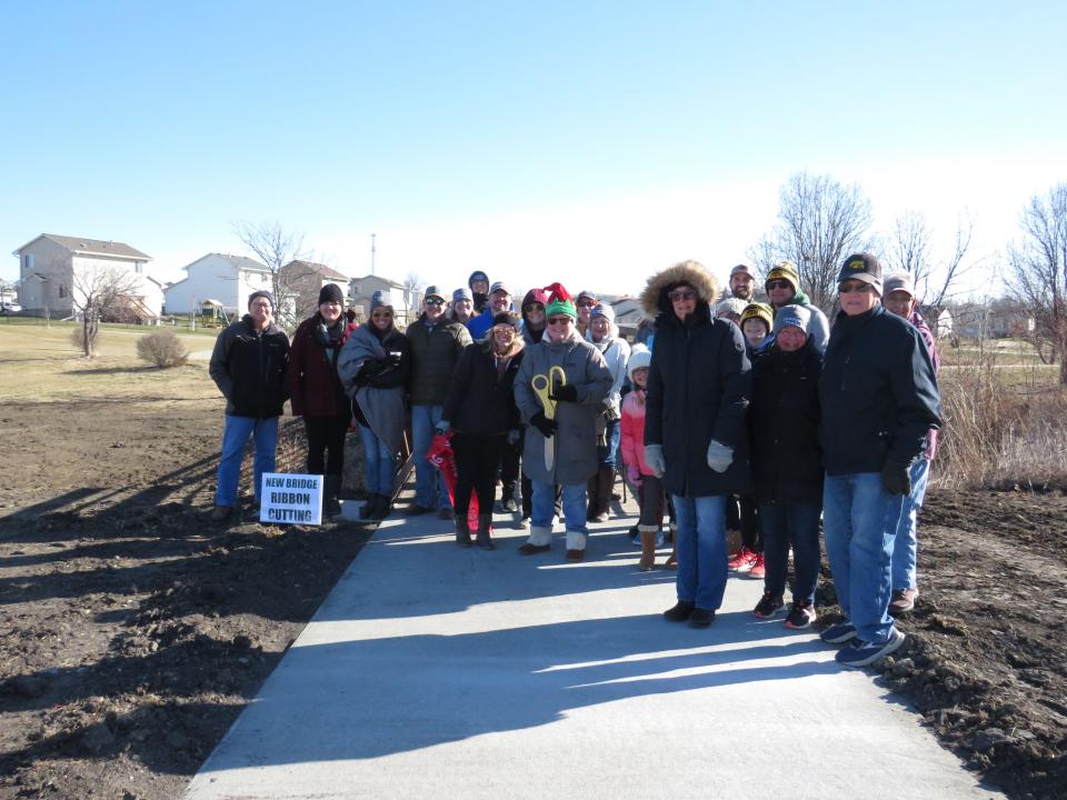 Attendees pose for a photo after the ribbon was be cut on Saturday, Dec. 3, 2022, for the new bridge crossing Oxley Creek in Granger.