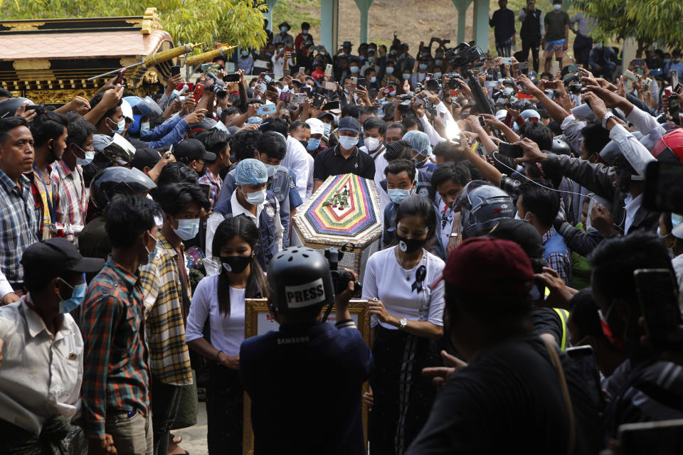 The casket containing the body of Mya Thwet Thwet Khine is carried through the crowds towards the cemetery in Naypyitaw, Myanmar, Sunday, Feb. 21, 2021. Mya Thwet Thwet Khine was the first confirmed death among the many thousands who have taken to the streets to protest the Feb. 1 coup that toppled the elected government of Aung San Suu Kyi. (AP Photo)