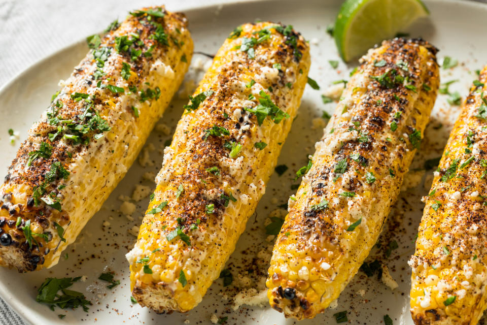 Four Mexican-style street corn on the cobs