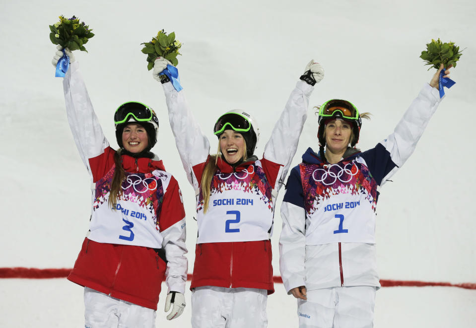 Canada's Justine Dufour-Lapointe, center, celebrates her gold medal in the women's moguls final, with her sister and silver medalist Chloe Dufour-Lapointe, left, and bronze medalist United States' Hannah Kearney, at the Rosa Khutor Extreme Park, at the 2014 Winter Olympics, Saturday, Feb. 8, 2014, in Krasnaya Polyana, Russia. (AP Photo/Andy Wong)