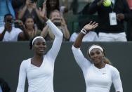 Venus Williams of the U.S. (L) and Serena Williams of the U.S.wave after defeating Oksana Kalashnikova of Georgia and Olga Savchuk of Ukraine in their women's doubles tennis match at the Wimbledon Tennis Championships, in London June 25, 2014. REUTERS/Max Rossi