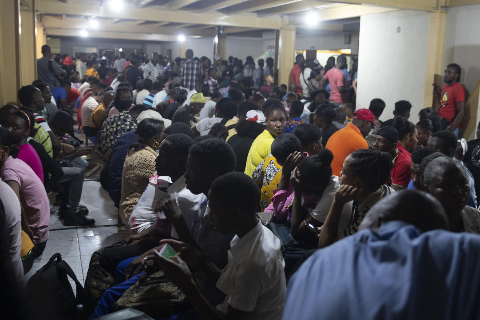 Haitians sit inside an immigration office as they wait their turns to apply for a passport, in Port-au-Prince, Haiti, Tuesday, Jan. 10, 2023. President Joe Biden announced a massive expansion of humanitarian parole on Jan. 5 for Cubans, Haitians, Venezuelans and Nicaraguans that is reserved for those who apply online, pay airfare and have a financial sponsor for two years. (AP Photo/Odelyn Joseph)