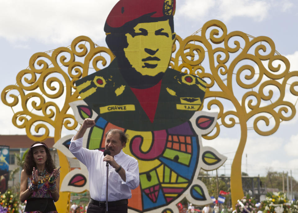 El presidente nicaragüense Daniel Ortega, acompañado de su esposa Rosario Murillo, habla durante un evento en conmemoración del aniversario de la muerte del presidente venezolano Hugo Chávez en Managua el 5 de marzo del 2014. (Foto AP/Esteban Felix)