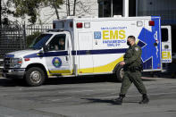 A Santa Clara County Sheriff's officer walks in front of an ambulance outside of Santa Clara Valley Medical Center during the coronavirus pandemic in San Jose, Calif., Wednesday, Jan. 13, 2021. (AP Photo/Jeff Chiu)