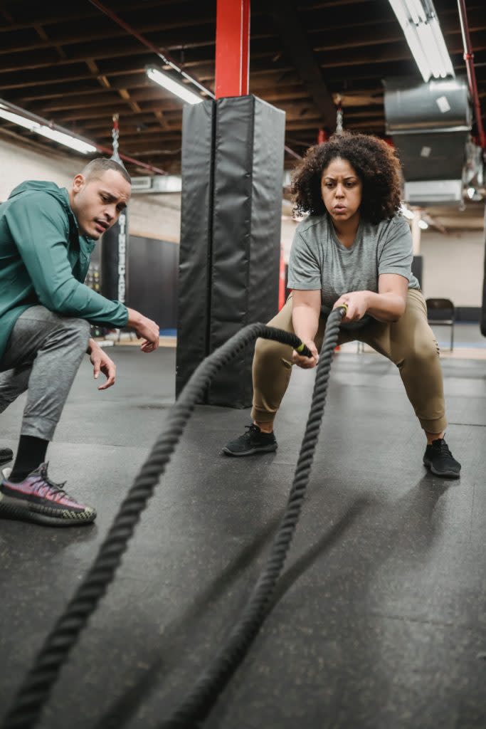 Black woman exercising with a personal trainer