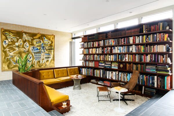 A sunken library houses Paul’s extensive Jane Austen collection. Built-in walnut seating, also by Lutz Wood, is covered in Cortina Leathers cushions. A 1960s Hungarian tapestry hangs nearby.