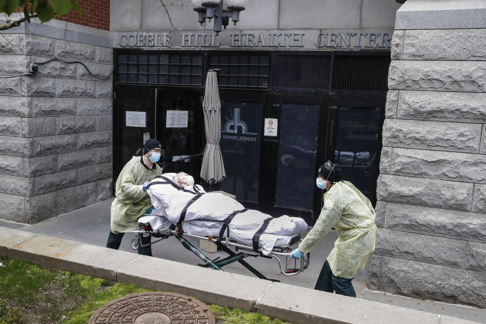A patient is wheeled out of Cobble Hill Health Center by emergency medical workers, Friday, April 17, 2020, in the Brooklyn borough of New York. The despair wrought on nursing homes by the coronavirus was laid bare Friday in a state survey identifying numerous New York facilities where multiple patients have died. Nineteen of the state's nursing homes have each had at least 20 deaths linked to the pandemic. Cobble Hill Health Center was listed as having 55 deaths. (AP Photo/John Minchillo)