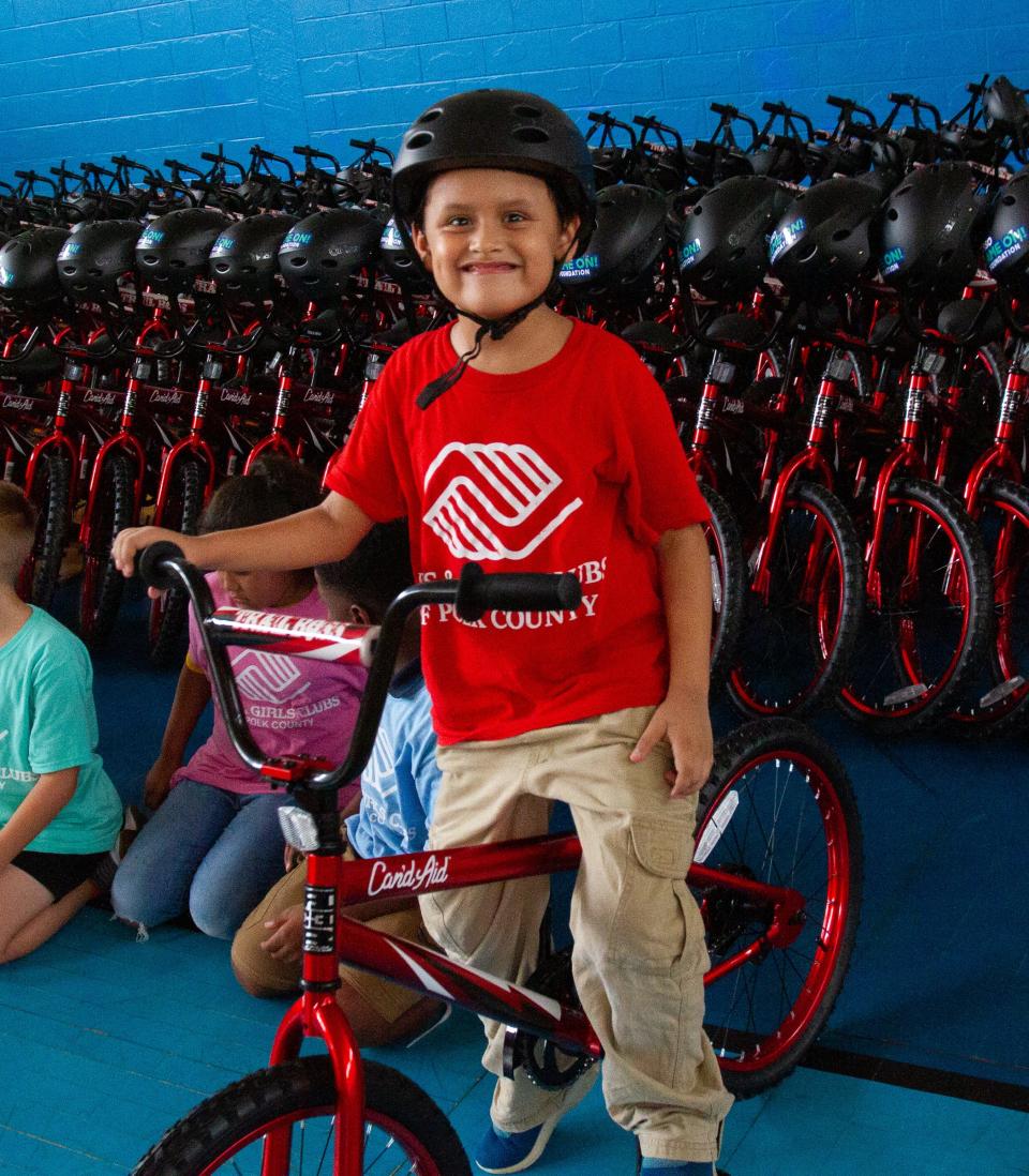 Franzier Vazquez, 7, tries out his new bicycle Wednesday afternoon during a bike giveaway at the Boys and Girls Clubs of Polk County's James J. Musso Unit in Lakeland. Can'd Aid and the Yasso Game On! Foundation gave away 100 bicycles.