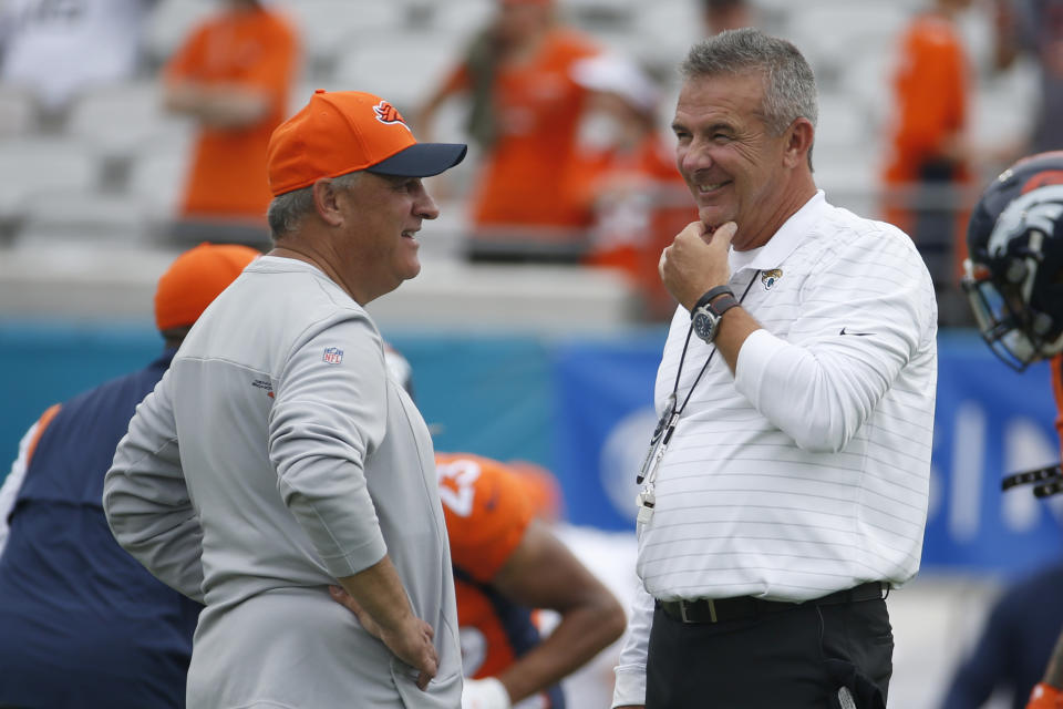 Denver Broncos head coach Vic Fangio, left, and Jacksonville Jaguars head coach Urban Meyer greet each other before an NFL football game, Sunday, Sept. 19, 2021, in Jacksonville, Fla. (AP Photo/Stephen B. Morton)