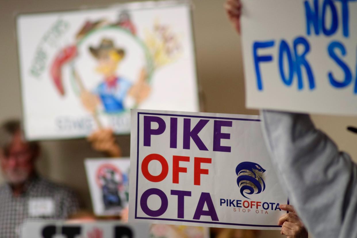 Turnpike protesters hold signs during a meeting of the Oklahoma Turnpike Authority at the Oklahoma Department of Transportation Tuesday, January 3, 2023.