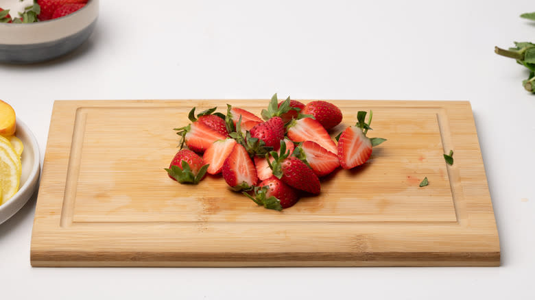 sliced strawberries on cutting board