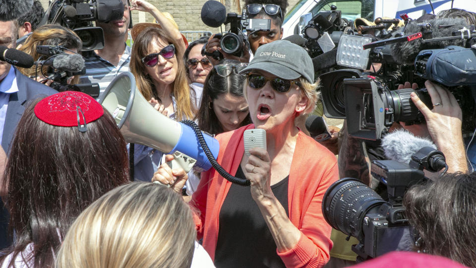 Democratic presidential candidate Sen. Elizabeth Warren, D-Mass., speaks through a megaphone while surrounded by the media outside the Homestead Detention Center, where the U.S. is detaining migrant teens, in Homestead, Fla., Wednesday June 26, 2019. (Daniel A. Varela/Miami Herald via AP)
