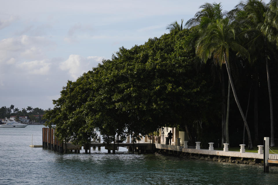 A law enforcement agent stands watch at the edge of a property belonging to rapper Sean "Diddy" Combs as it is searched by federal agents, Monday, March 25, 2024, on Star Island in Miami Beach, Fla. Two properties belonging to Combs in Los Angeles and Miami were searched Monday by federal Homeland Security Investigations agents and other law enforcement as part of an ongoing sex trafficking investigation by federal authorities in New York, two law enforcement officials told The Associated Press. (AP Photo/Rebecca Blackwell)