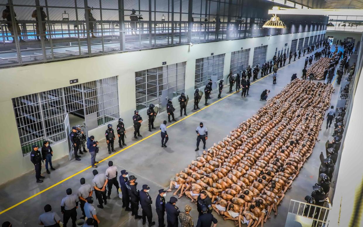 Police officers in riot gear guarding the arrival of inmates belonging to the MS-13 and 18 gangs to El Salvador's new prison "Terrorist Confinement Centre" - AFP