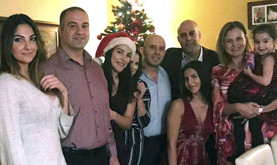In this Dec. 25, 2018, photo provided by Guila Fakhoury, her father Amer Fakhoury, third from right, gathers with his family on Christmas in Salem, N.H. Amer Fakhoury, a U.S. citizen living in Dover, N.H., went to visit family in his native Lebanon in September after a 20-year absence, and has been jailed there by authorities since. (Guila Fakhoury via AP)