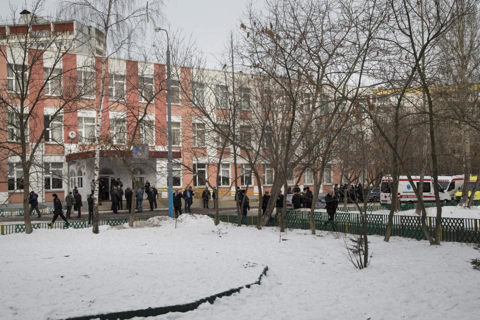 Police officers walk past parked ambulances at an entrance to a Moscow school on Monday, Feb. 3, 2014. An armed teenager burst into his Moscow school on Monday and killed a teacher and policeman before being taken into custody, investigators said. None of the children who were in School No. 263 were hurt, said Karina Sabitova, a police spokeswoman at the scene. The student also wounded a second police officer who had responded to an alarm from the school, she said. (AP Photo/Alexander Zemlianichenko)