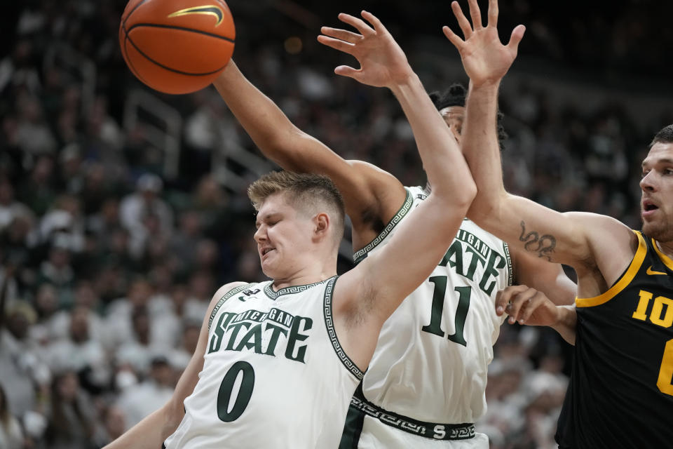 Michigan State forward Jaxon Kohler (0), guard A.J. Hoggard (11) and Iowa forward Filip Rebraca (0) reach for the rebound during the first half of an NCAA college basketball game, Thursday, Jan. 26, 2023, in East Lansing, Mich. (AP Photo/Carlos Osorio)