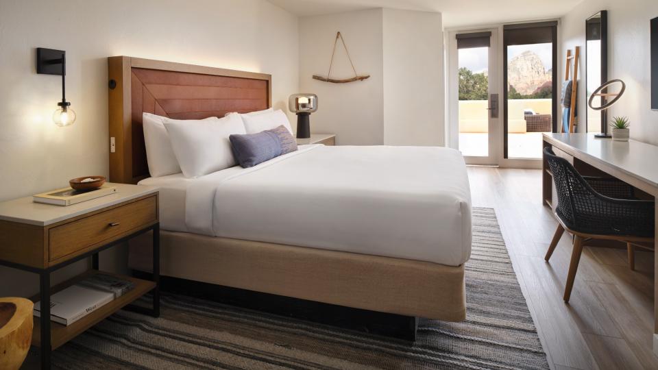 A white bed in front of a window that looks out on Sedona, Arizona, at the Sky Rock Sedona hotel