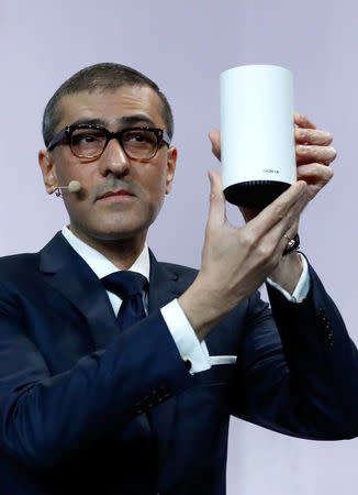 Rajeev Suri, Nokia's President and Chief Executive Officer, shows a wi-fi device during the Mobile World Congress in Barcelona, Spain February 25, 2018. REUTERS/Yves Herman