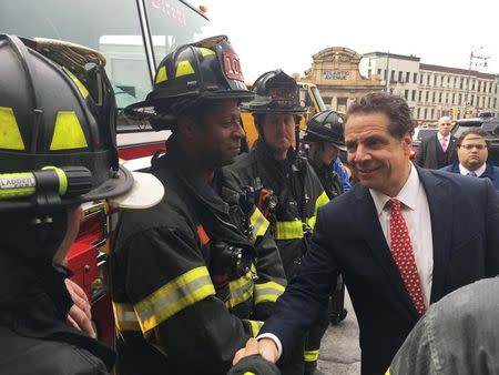 Governor Andrew Cuomo greets members of the New York Fire Department after a commuter train derailed during the Wednesday morning commute, in New York, U.S., January 4, 2017. REUTERS/Stephanie Brumsey