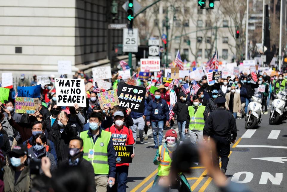 People march with signs that say 'Stop Asian Hate'