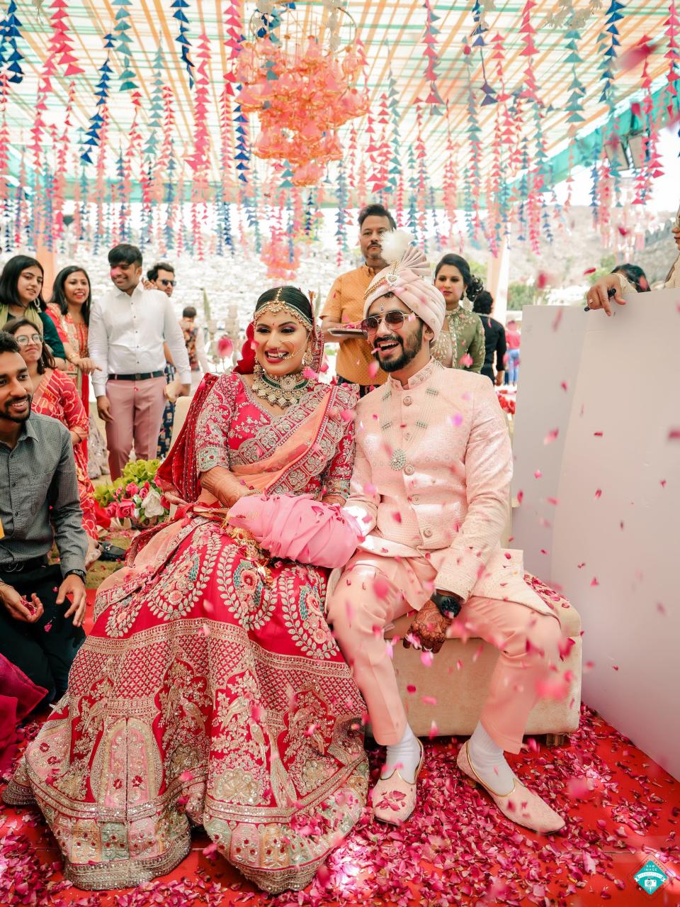 A bride and groom sit together and smile during their wedding ceremony.