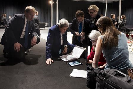 U.S. Secretary of State John Kerry and staff look at a tablet following Iranian nuclear talks at the Swiss Federal Institute of Technology in Lausanne (Ecole Polytechnique Federale De Lausanne) April 2, 2015. REUTERS/Brendan Smialowski/Pool