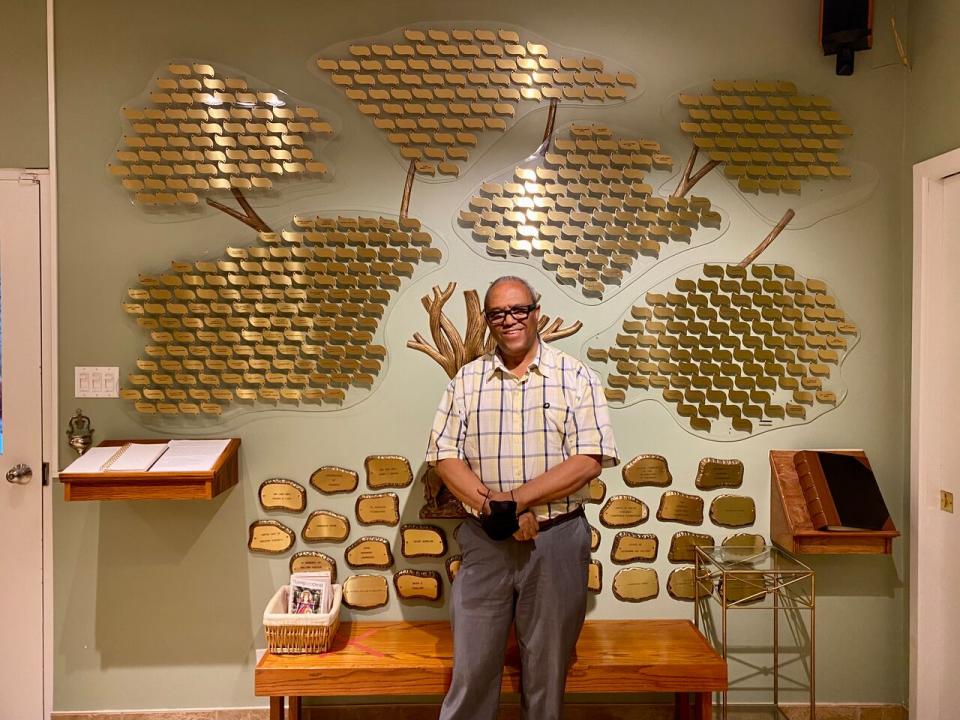 Aklilu Wendaferew stands in front of Good Shepherd Toronto's donation plaques. He says the shelter feels more prepared to deal with monkeypox after lessons learned from the pandemic, but is worried about what remains unknown about monkeypox transmission. 