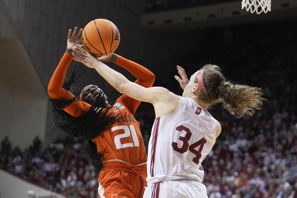 Miami's Lola Pendande (21) is fouled by Indiana's Grace Berger (34) during the second half of a second-round college basketball game in the women's NCAA Tournament Monday, March 20, 2023, in Bloomington, Ind. (AP Photo/Darron Cummings)