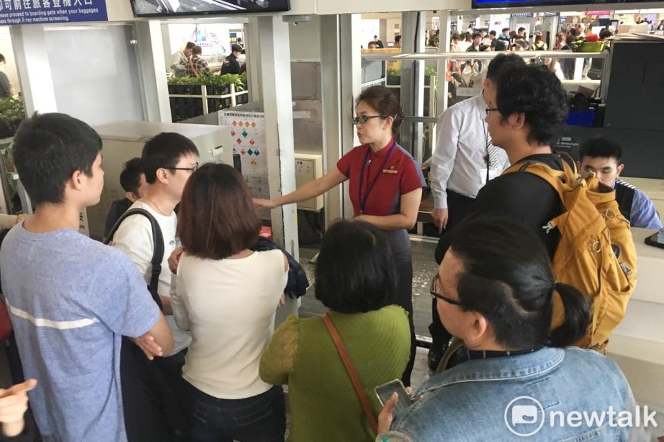華航地勤人員在華航高雄機場報到櫃檯前協助候補旅客候補順序。   圖：張良一攝