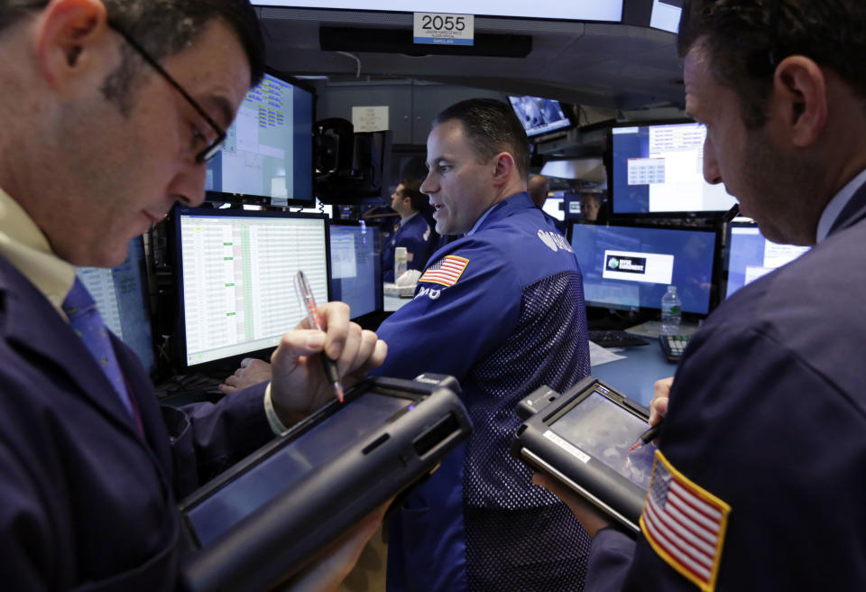 Traders gather at the post of specialist Jason Hardzewicz, center, on the floor of the New York Stock Exchange Monday, April 28, 2014. Stocks are mostly higher in early trading as traders hope for another blockbuster merger in the health-care industry. (AP Photo/Richard Drew)