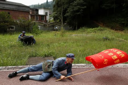 Participants dressed in replica red army uniforms dodge a simulated attack on their march during a Communist team-building course extolling the spirit of the Long March, organised by the Revolutionary Tradition College, in the mountains outside Jinggangshan, Jiangxi province, China, September 14, 2017. REUTERS/Thomas Peter