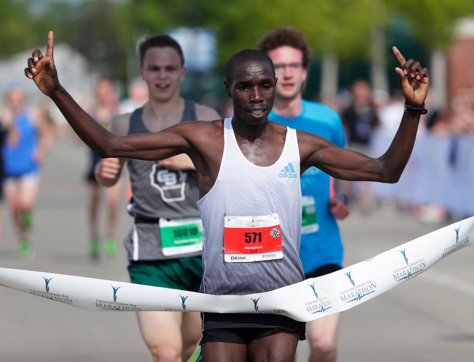 Vincent Kipchumba Toroitich celebrates as he crosses the finish line, winning the Cellcom Green Bay Marathon on Sunday.