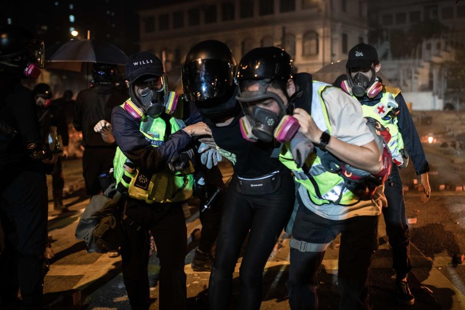 First aiders help to carry a wounded protester during the clashes with riot police in Hong Kong.