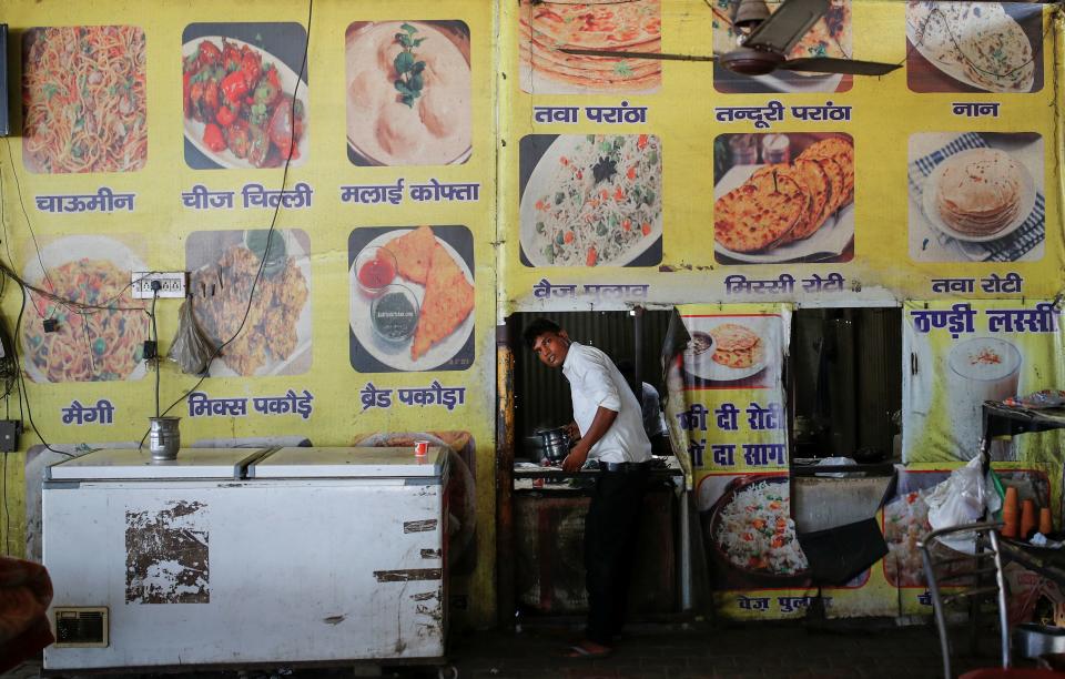 A waiter prepares to serve tea at a dhaba, a small restaurant along a national highway in Gharaunda