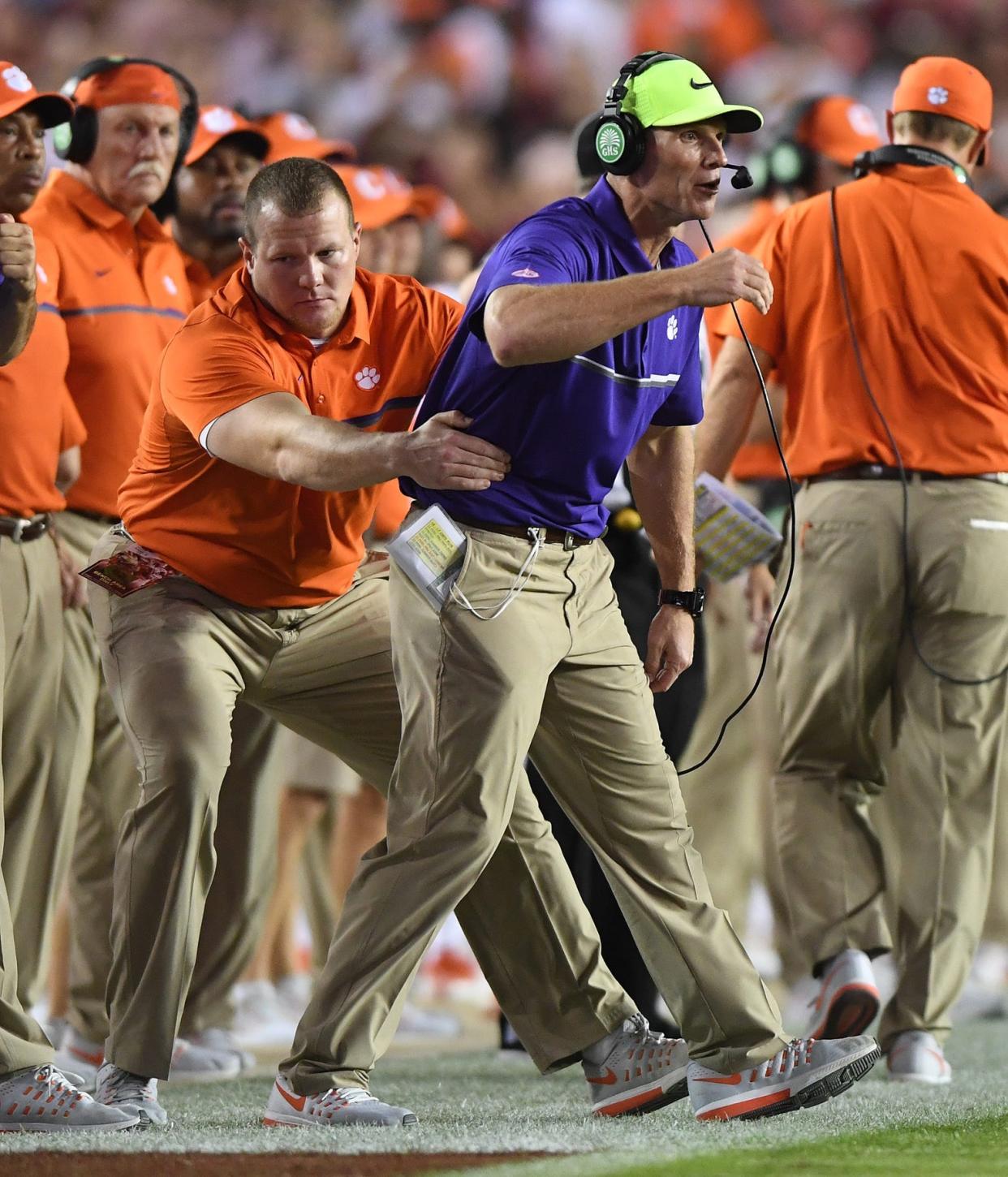 Clemson conditioning coach Adam Smotherman pulls defensive coordinator Brent Venables off the field during the 2nd quarter at Florida State's Doak Campbell Stadium in Tallahassee, Florida, on Saturday, Oct. 29, 2016.