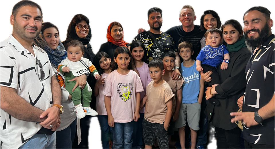 Jason Kander and Rahim Rauffi, back row center, with their families in Kansas City. From left: brother Najim Rauffi, sister-in-law Mursal, nephew Nadim, mother Shekiba, wife Rahima (red scarf), daughters Mahdia, Hadia and SanaTamkin, nephew Omid, son Samim, Kander’s son True and wife Diana, Rauffi’s sister-in-law Tooba, nephew Yousaf, brother Farhad.
